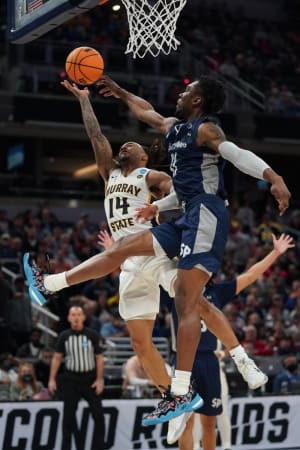 Murray State Racers guard Justice Hill (14) goes to the basket defended by St. Peter's Peacocks forward KC Ndefo (11) in the first half during the second round of the 2022 NCAA Tournament at Gainbridge Fieldhouse